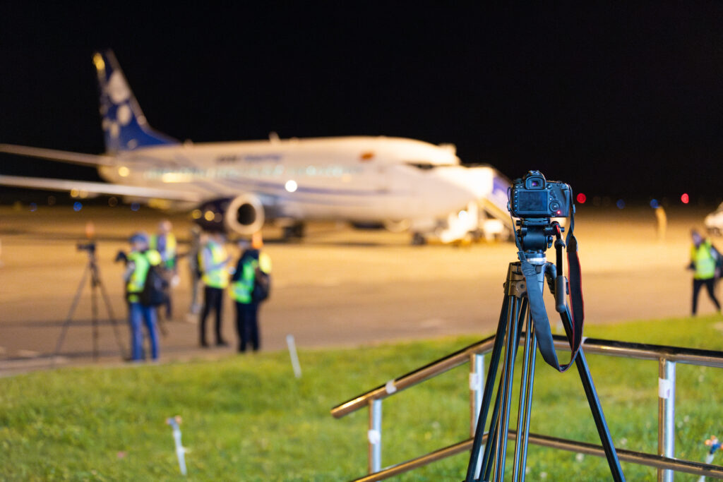 Camera sur un trepied prenant des images de l'aéroport de nuit